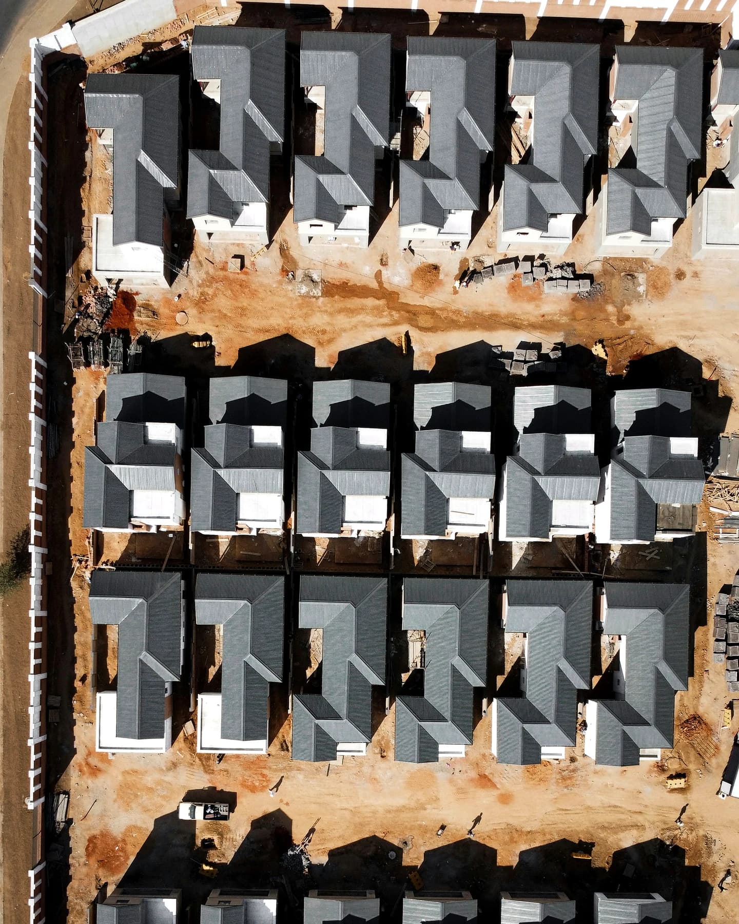 Aerial view of multiple low-rise homes under construction in a residential estate
