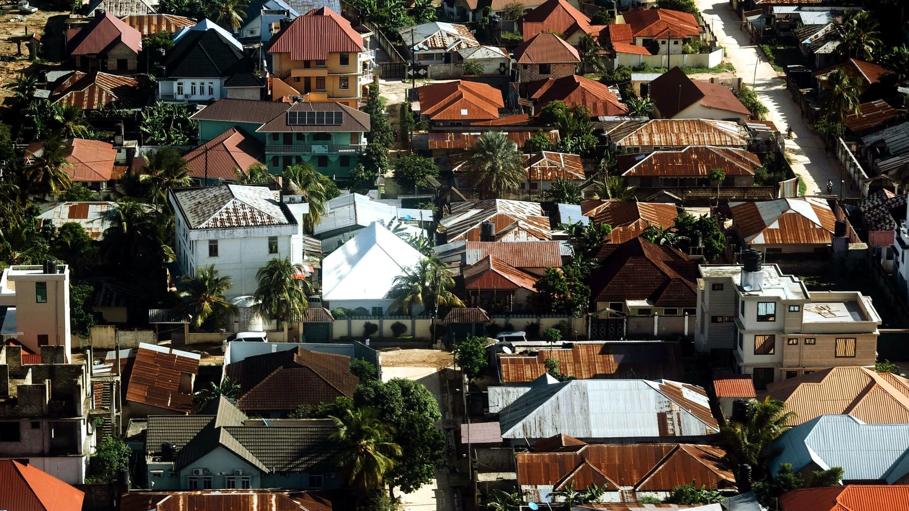 Aerial view of residential houses and roads in a Tanzanian coastal town