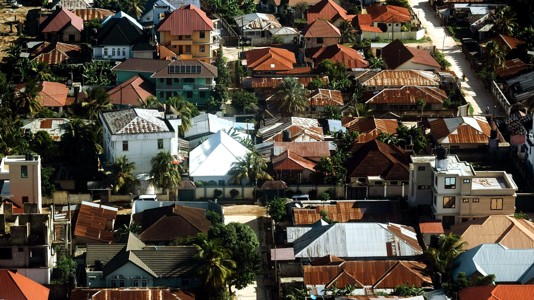 Aerial view of residential houses and roads in a Tanzanian coastal town